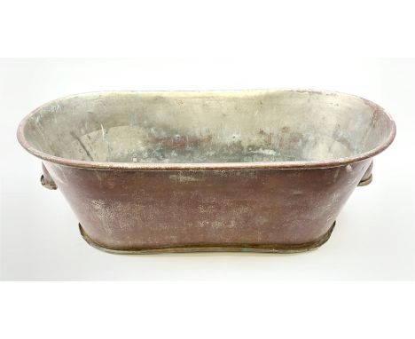 A late 19th/early 20th century twin bath with lug handles and applied brass plaque with monogram 'VA', (with drainage holes f