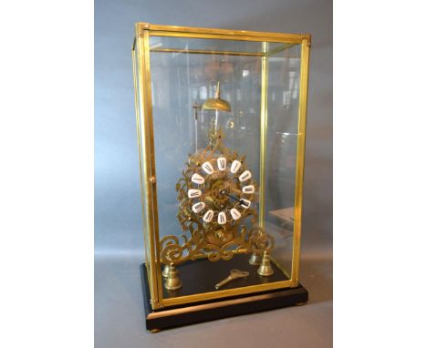 A 20th Century Brass Skeleton Clock of Gothic form with ceramic tablet Roman numerals and with single fusee movement striking