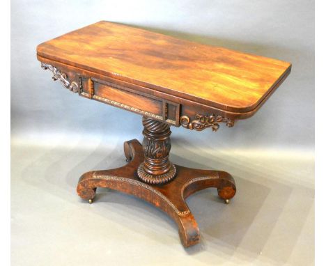 A William IV Mahogany Card Table, the hinged top enclosing a baise lined interior above a shaped and carved frieze with tulip