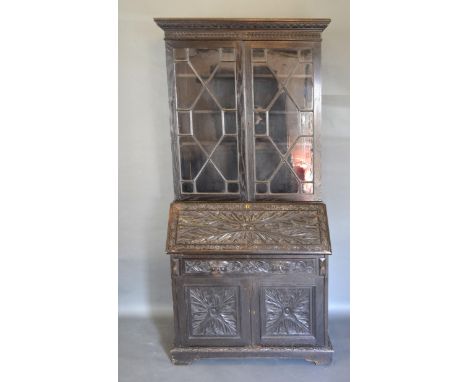 A Victorian Carved Oak Bureau Bookcase, the moulded cornice above two astragal glazed doors enclosing shelves, the lower sect