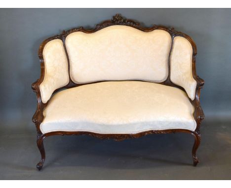 A Late 19th Early 20th Century French Mahogany Salon Sofa, the shaped carved and upholstered back above a serpentine over stu