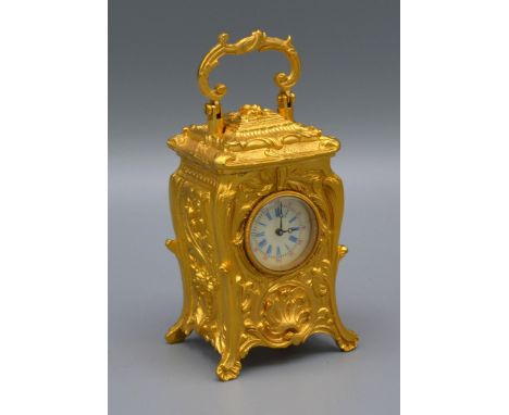 A Brass Cased Carriage Clock of Rococo Form with circular enamel dial 7cms tall 