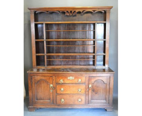 A George III Oak Dresser, the moulded cornice and boarded shelf back above a lower section with three central drawers flanked