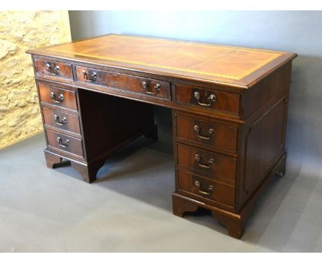 A Reproduction Mahogany Twin Pedestal Desk, the tooled leather inset top above nine drawers with brass handles raised upon br