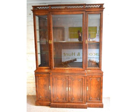A 20th Century Mahogany Break Front Bookcase, the moulded cornice with pierced gallery above three glazed doors enclosing she