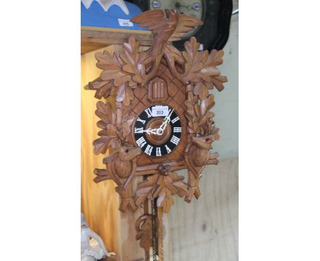 A vintage cuckoo clock with pendulum and weights.Condition:- General wear through age and use, small crack and nails through 