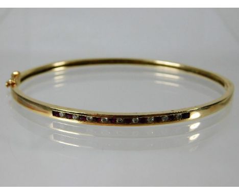 A 10ct gold bangle set with approx. 0.2ct diamond &amp; ruby 7.3g
