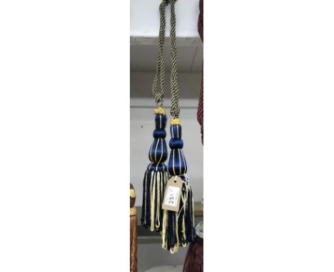 A pair of blue and gold curtain tie backs with tassel