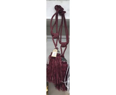 A pair of large red wine curtain tie backs with large gem effect embellishment and tassels&nbsp;