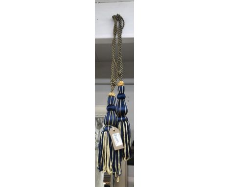 A pair of curtain tie backs in blue and gold with tassels&nbsp;