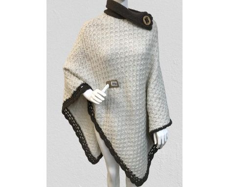 A Vintage Chunky Poncho shawl with brown trim and button detail to neck.