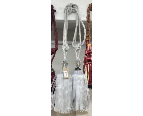 A pair of sliver curtain tie backs with large gem effect embellishment and tassels