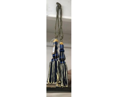 A pair of royal blue and gold curtain tie backs with tassels