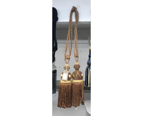 One pair of burnt orange and brown curtain tie backs with gold embellishment