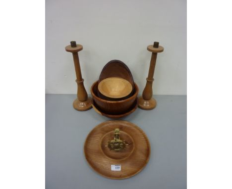 Four treen bowls, wood and brass nutcracker bowl and a pair of turned wood candlesticks 