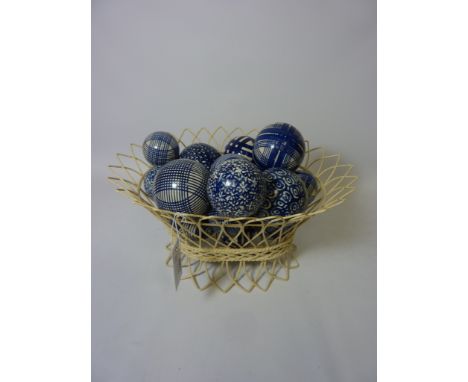 Collection of blue and white hand painted ceramic balls in wirework basket