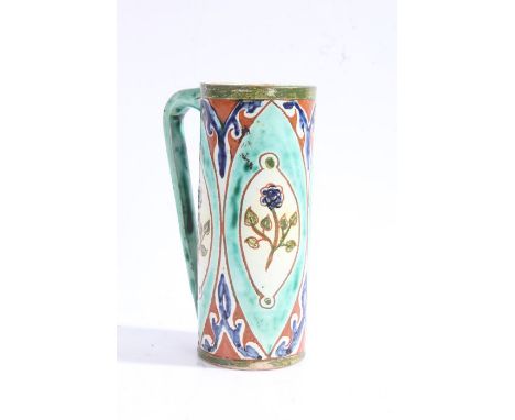 Della Robbia pottery mug, c1894-1906, with a blue and green ground set with floral panels, marks to the base J S, 12cm high