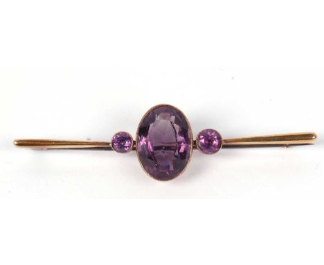 Vintage amethyst brooch, the large faceted oval shaped amethyst is 18x12mm, flanked by two small round amethysts, each indivi
