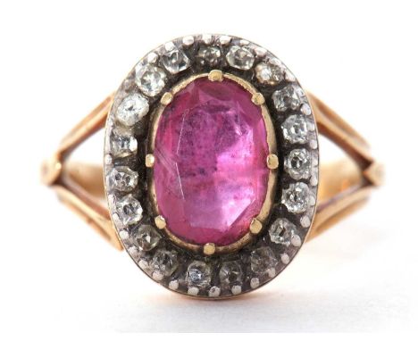 Antique ruby and diamond cluster ring, the oval shape faceted ruby is 10 x 7 mm approx, multi claw set in a cut down setting 