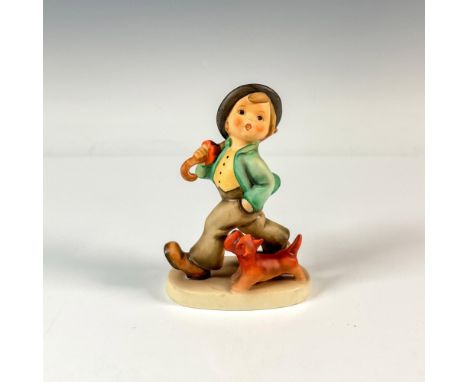 A hand painted matte figure of a dapper boy carrying his umbrella as his dog walks beside him. M.I. Hummel impressed. Goebel 