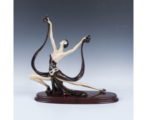 Hand painted resin figure of an art deco dressed beauty in a purple dress in a performative stance. The sculpture attached to