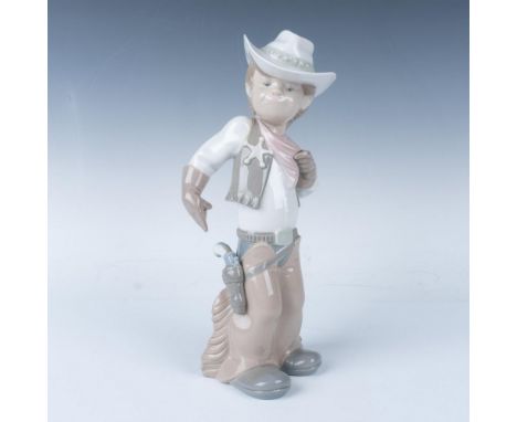 Glazed figure of a cheerful and bold cowboy smiling while pointing to the gun in his pocket. Lladro backstamp. Artist: Juan H