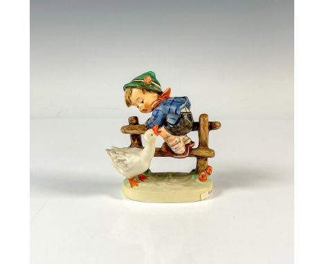 A figure of a boy who is climbing a fence as a curious goose honks at him. M.I. Hummel impressed. Goebel backstamp. Issued: 1