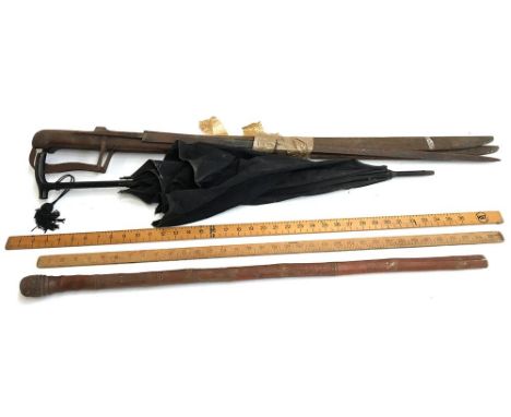 A pair of oriental swords and another blade; a vintage umbrella; a bamboo walking stick; and two yard rules 