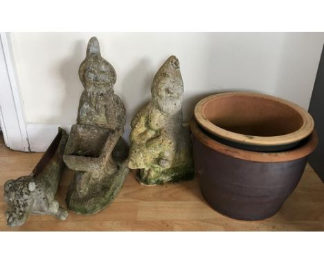 Three composite stone figures, one a boot scraper in the form of a Dachshund, together with two ceramic planters 