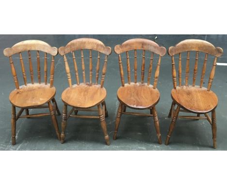 A good set of four kitchen chairs, each with the shaped rail supported of six ring turned spindles, above a circular shaped s
