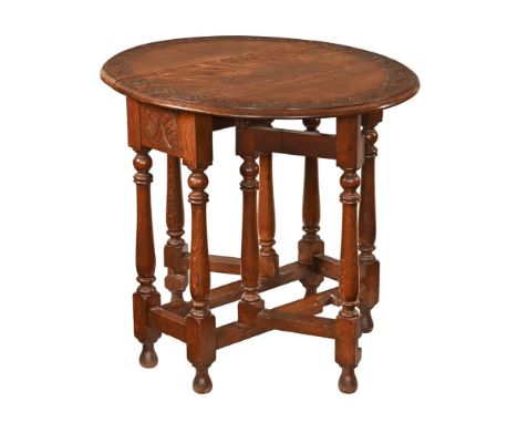 A carved oak gate legged table, with turned supports and low stretchers.  Height 79 cm, width 76.5 cm, depth flaps down 35.5 