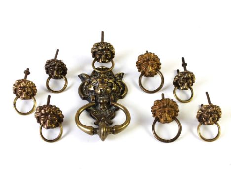 A vintage brass lions head door knocker, and eight similar designed handles.