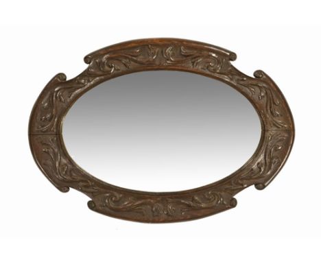 A carved oak framed bevel edged oval mirror, frame size 83 cm x 58 cm, mirror size 61.5 cm x 38 cm.