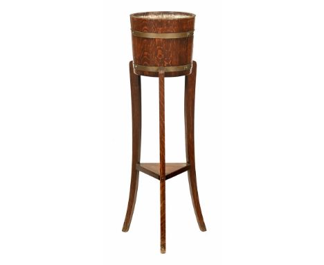 An oak and brass bound plant stand.  Height 90 cm, diameter at the top 26 cm.