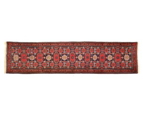 An Iranian fringed runner, principal colours red, blue, light blue and beige and with multiple line border.  360 cm (excludin