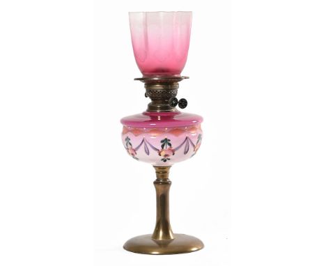 A late 19th/early 20th century oil lamp with double burners, pink and red glass painted reservoir, gallery and etched red gla
