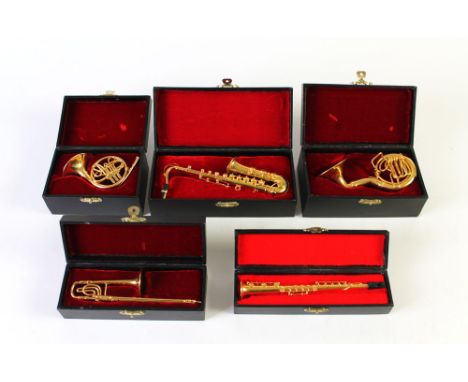 A collection of five boxed miniature brass musical instruments, French horn, Clarinet, Saxophone, Trombone and a Sousaphone. 