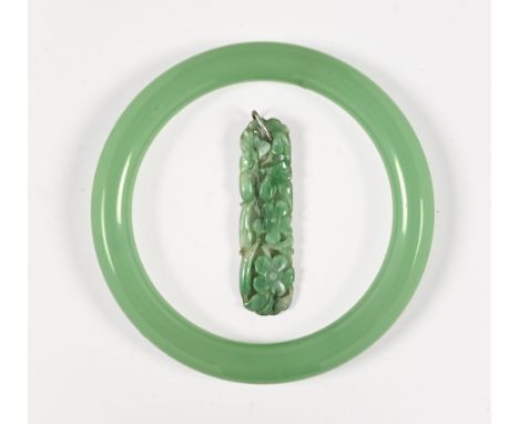 A carved green jade pendant and bangle.