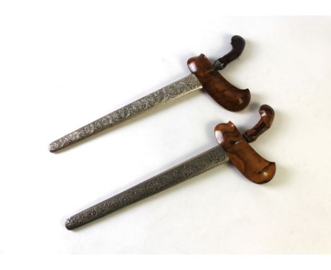 Two silver coloured metal mounted Balinese Kris, with olive wood handles and scabbards.  Longest 52 cm. This bladed product i