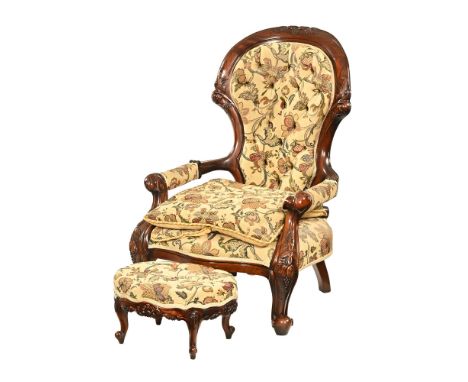 A Victorian style armchair, with oval footstool, deep buttoned in foliate patterned fabric.  Armchair height to top of back 9