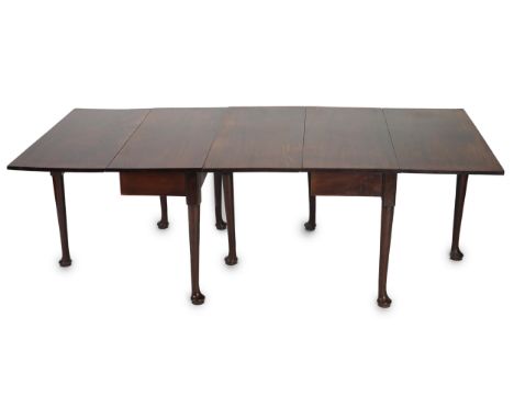 A George II mahogany double drop leaf dining table, one section with twin flaps, the other with single flap, on turned tapere