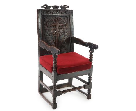 A 17th century and later Yorkshire oak Wainscot elbow chair, the panelled back carved with stylised dragon and foliate motifs