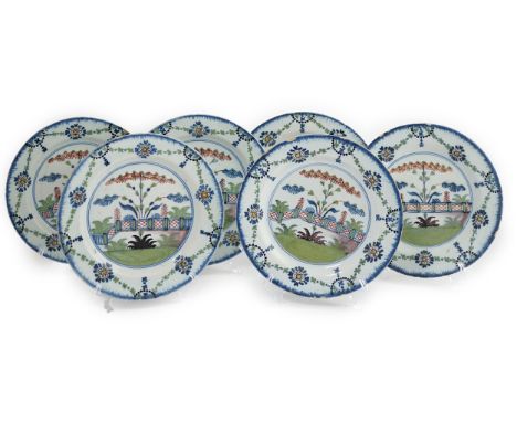 A set of six London delftware polychrome plates, late 18th century, each painted with a fenced garden scene within flower swa