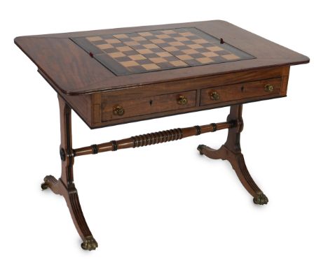 A Regency mahogany games table with rounded rectangular topped, fitted to the centre with a reversible folding backgammon and