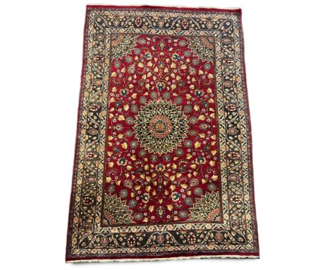 A Tabriz red ground carpet with central medallion and field of foliate motifs, multi bordered, 293 x 193cm PLEASE NOTE:- Pros