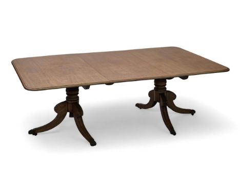 A Regency mahogany extending dining table, the rounded rectangular top with one spare leaf, on ring turned pillars with acant