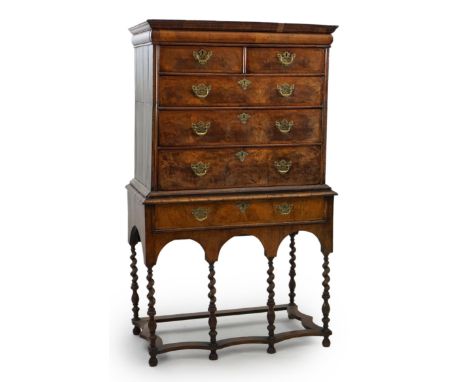 An early 18th century walnut chest on stand with cushion frieze drawer over two short and three graduated long drawers, on st