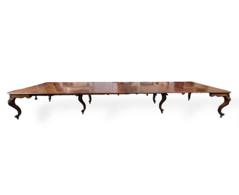 An unusually large William IV mahogany extending dining table, the rounded rectangular top with eight leaves over a scroll ca