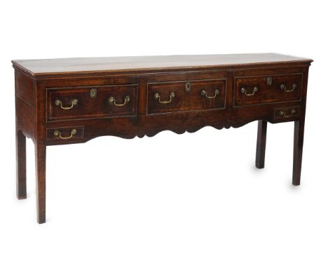 A mid 18th century oak dresser base fitted three frieze and two small apron drawers, on squared legs, 176cm wide, 45cm deep, 