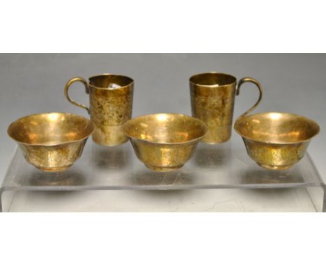 A set of three Japanese silver sake cups, flared rims, planished overall, 5.5cm diam, signed, Meiji period; a pair of tots, e